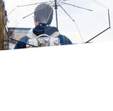 A photo of someone using a clear umbrella with a backpack in the rain. 