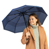 A woman holding the navy blue travel compact umbrella that is windproof and best selling from Repel Umbrella