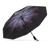 The Starry Night Top Best-Selling Windproof Compact Travel Umbrella is pictured on it's own, open and leaning to the left. The Canopy is black and the interior shows off the starry night motif.