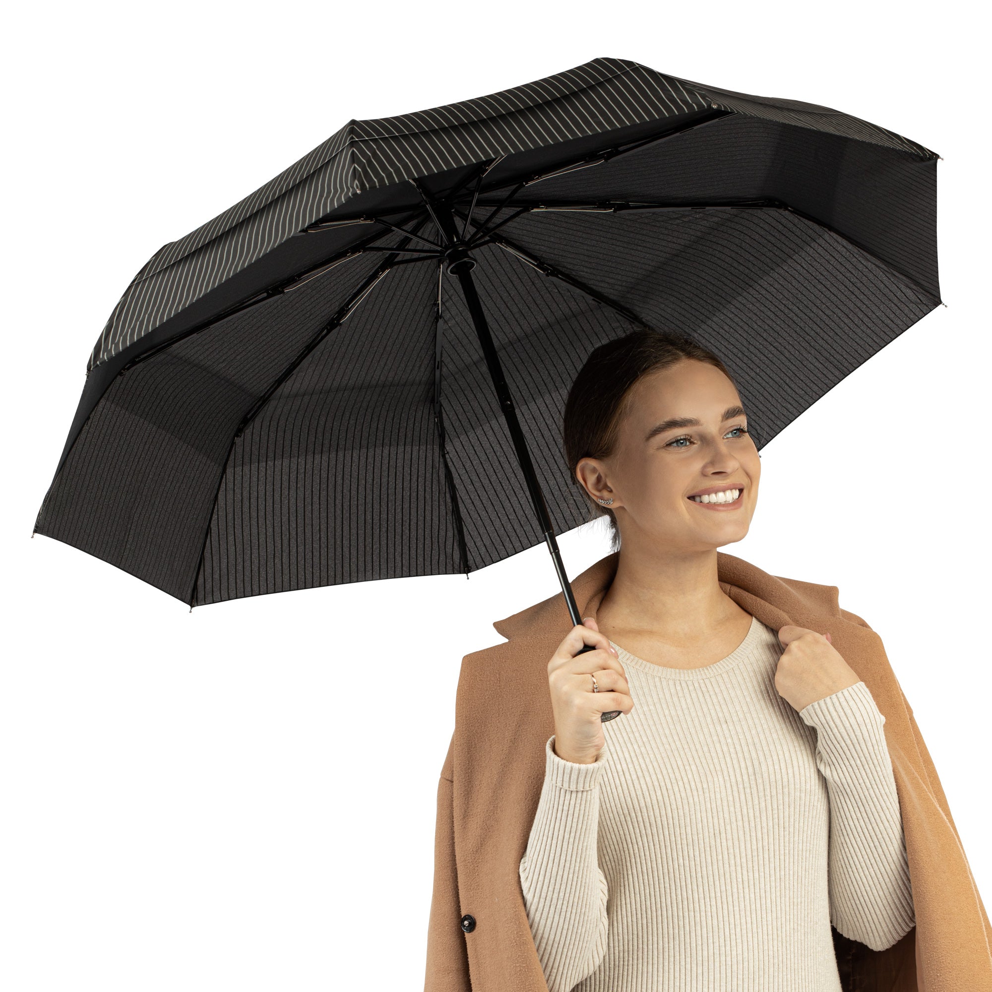 A woman holding the windproof travel compact umbrella by Repel Umbrella in pin stripe