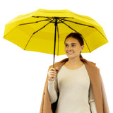 A woman holding the yellow travel compact umbrella that is windproof and best selling from Repel Umbrella